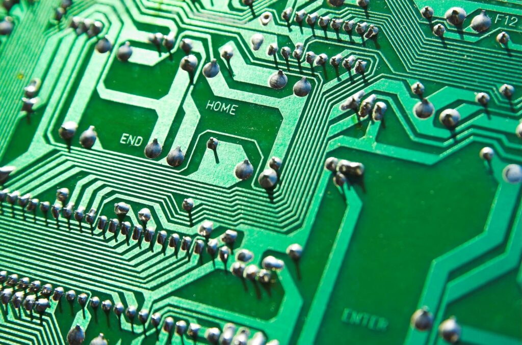 Detailed view of green circuit board with visible chips and pathways, highlighting technology elements.
