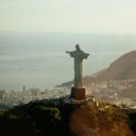 Majestic aerial view of Christ the Redeemer statue overlooking Rio de Janeiro at sunset.