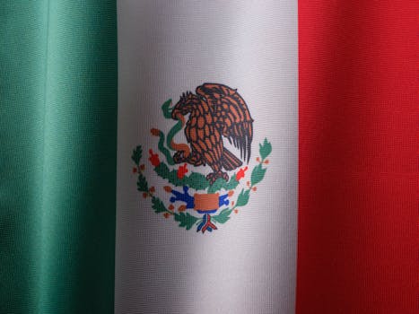 Detailed close-up of the Mexican flag with vibrant colors and fabric texture.